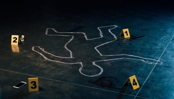 chalk outline and evidence markers at crime scene. (Foto: banco de imagens)