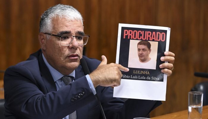 Eduardo Girão (Novo-CE) mostra foto de Lulinha durante sessão da CPMI do INSS. (Foto: Carlos Mo...